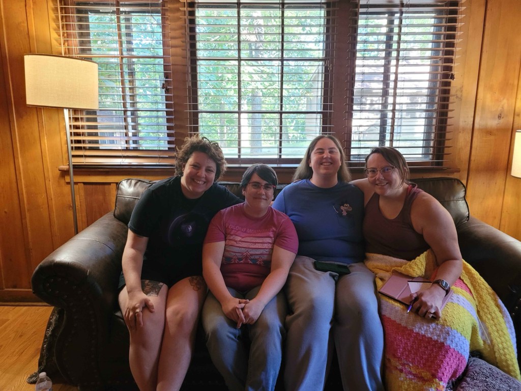 Nahtagain, redria64, sekhmetlives, and Katryam smiling and hugging on a couch