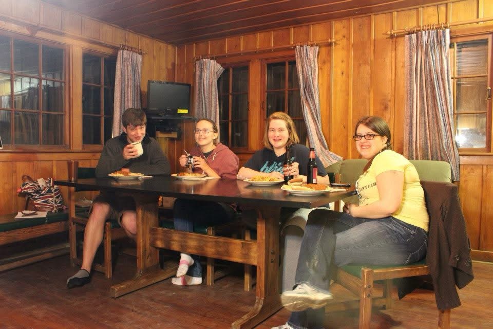 Twelve years ago, four people sit smiling at a table, getting ready to eat a spaghetti dinner