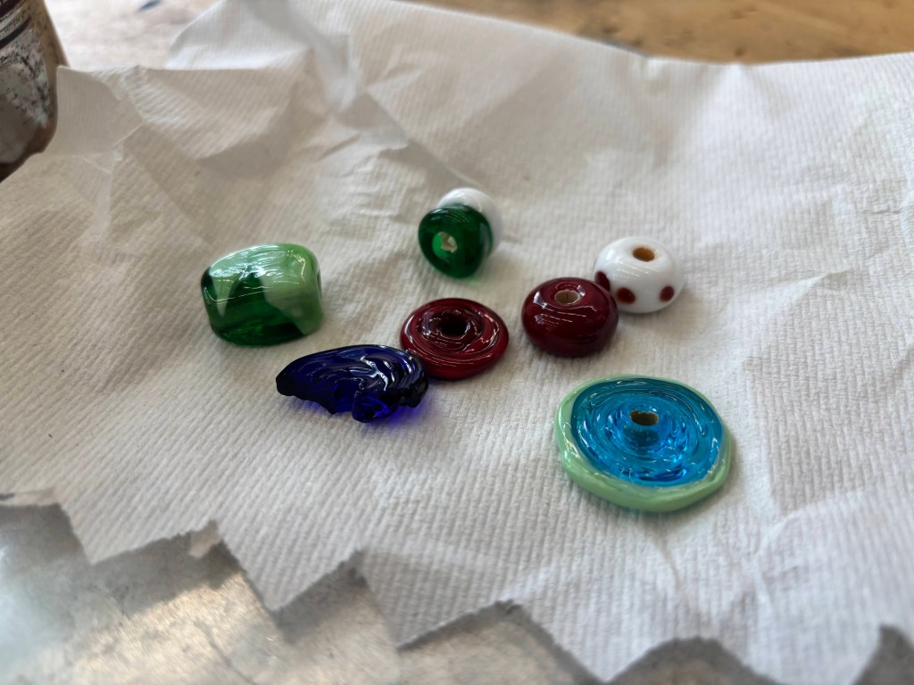 A group of colorful glass beads, made by the author. They are all unique and shiny.