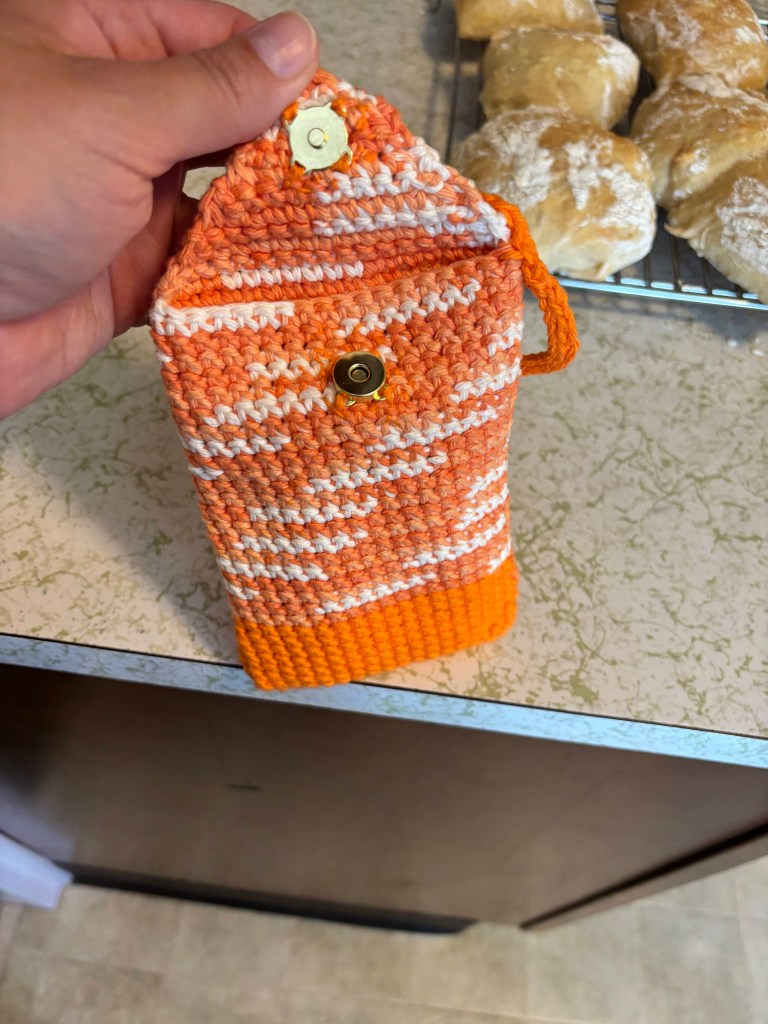 A variegated orange bag with a magnet snap